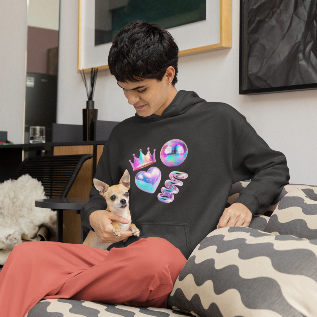 A man in a black hoodie with abstract prints, sitting on a couch with a dog on his lap.