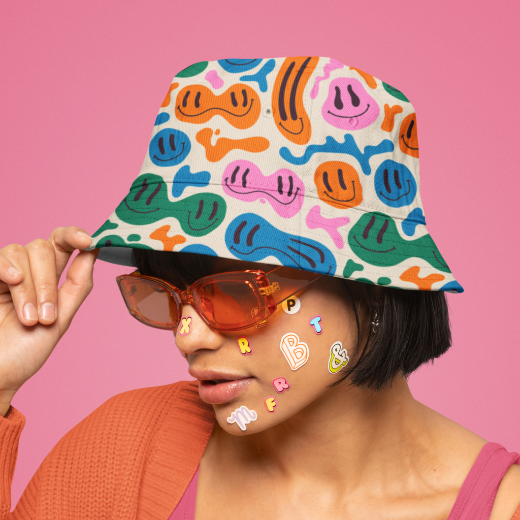 A woman in a custom bucket hat on a pink background.