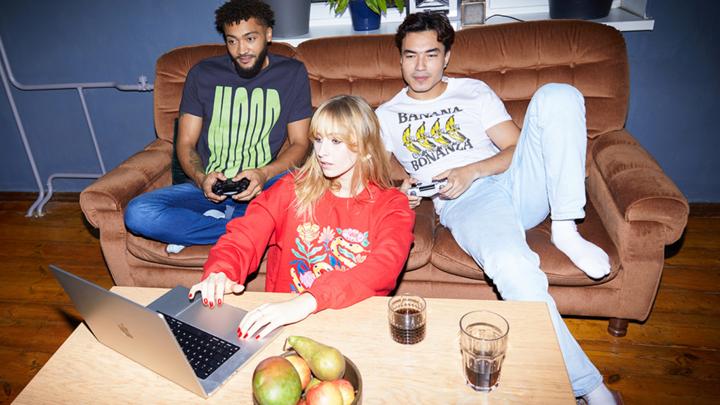 A group of people (2 men and 1 woman) wearing custom apparel made with print-on-demand.