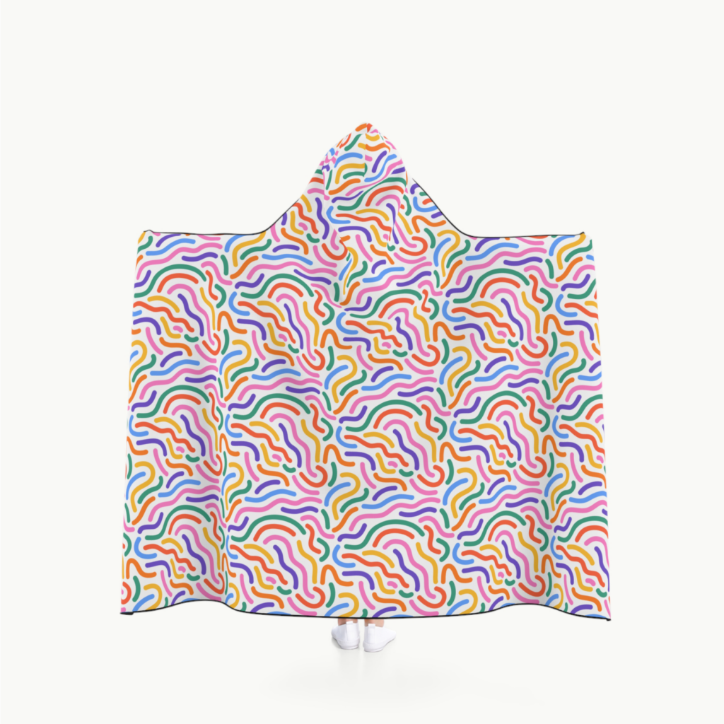 A person wearing a custom hooded blanket with an abstract all-over-print on the backside.