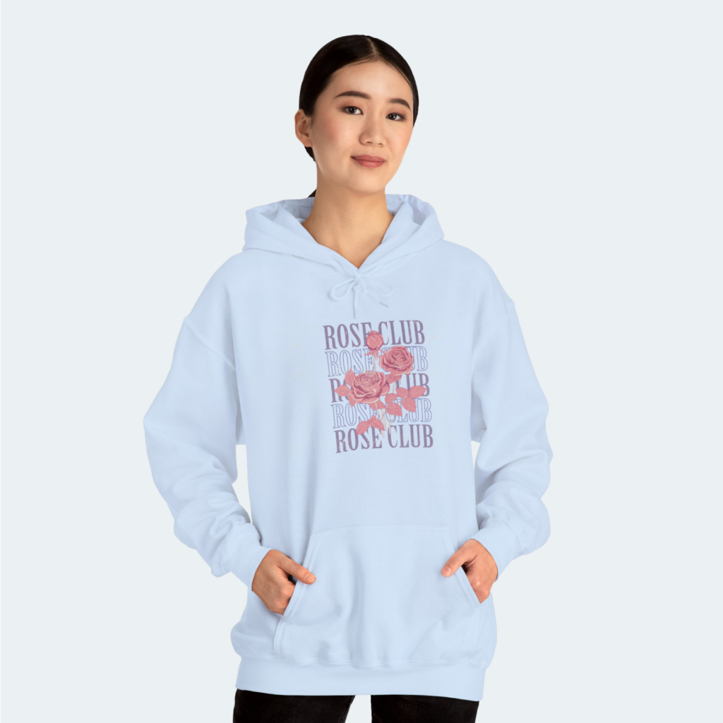 A woman in a light blue “Rose Club” hoodie against a white background.