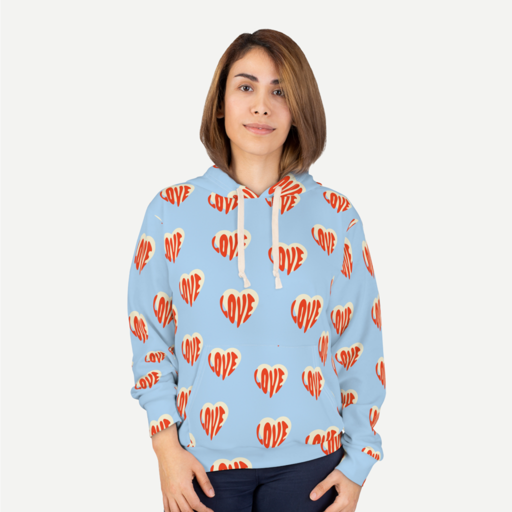 A woman in a light blue hoodie with heart-shaped prints all over against a white background.