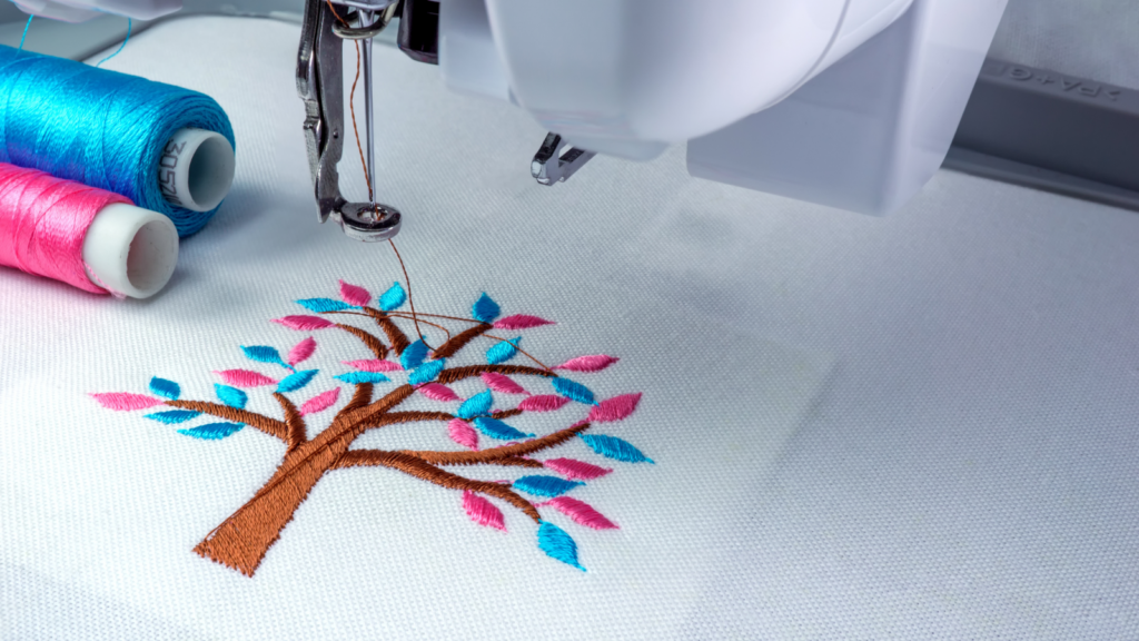 A sewing machine featuring a beautifully embroidered tree design on its fabric surface.